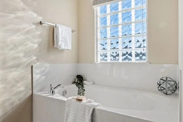 a bathroom with a tub sink and mirror
