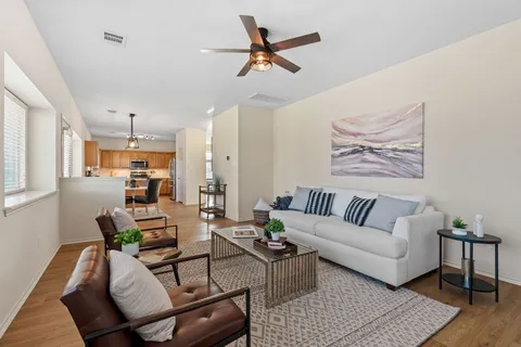 a living room with furniture a ceiling fan and a rug