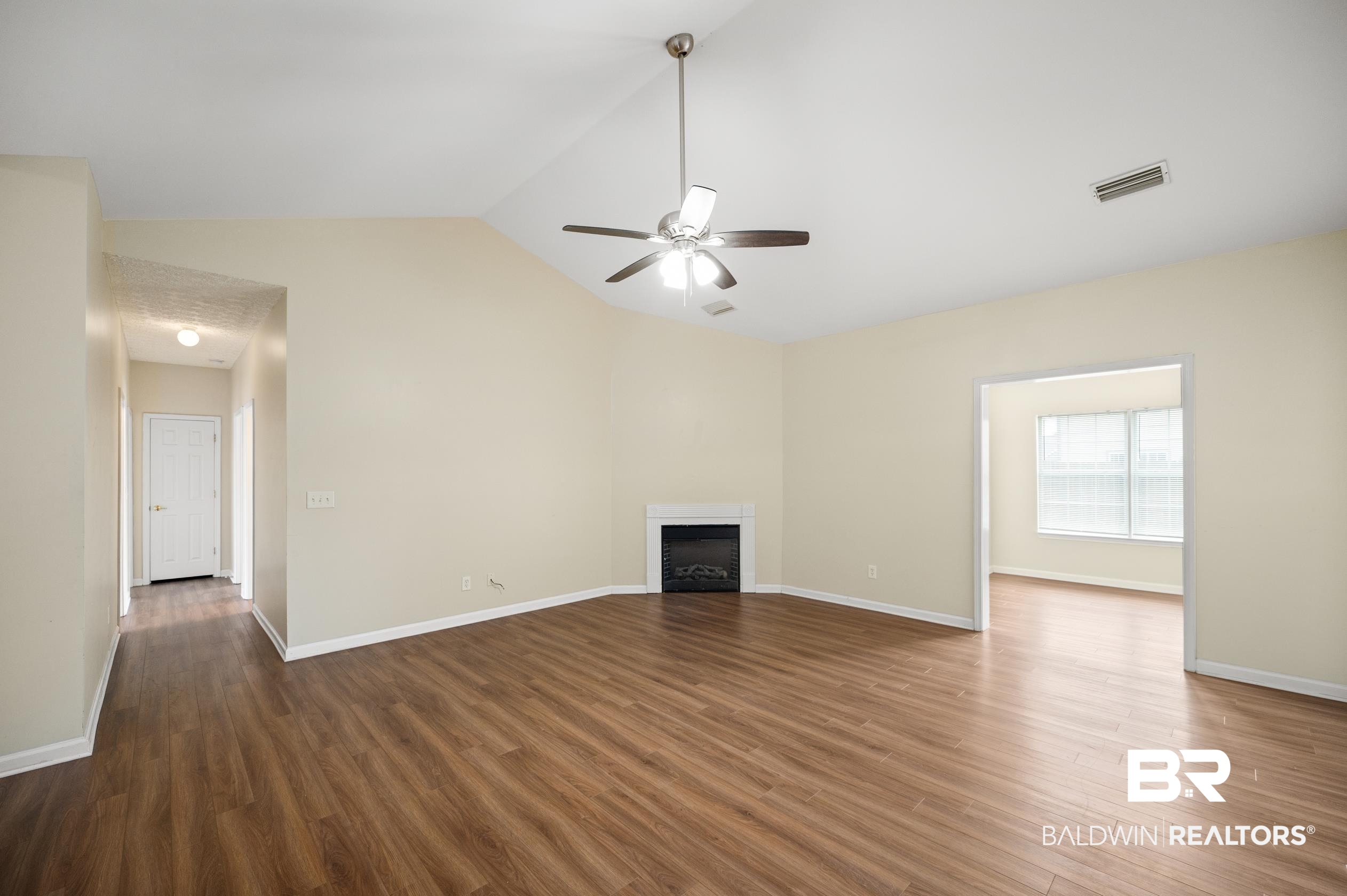 1333 Dominoe Trail Foley, AL 36535 - Photo 3 of 32 Unfurnished living room with lofted ceiling, ceiling fan, and hardwood / wood-style floors