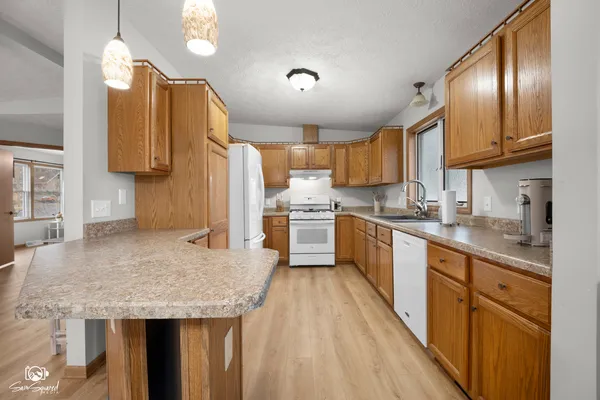 a kitchen with stainless steel appliances granite countertop a sink refrigerator and cabinets