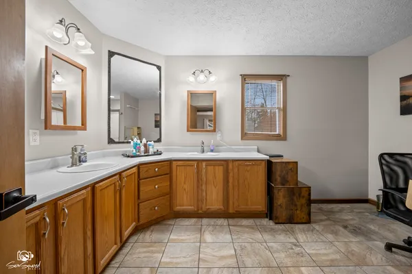 a spacious bathroom with a granite countertop sink and a mirror