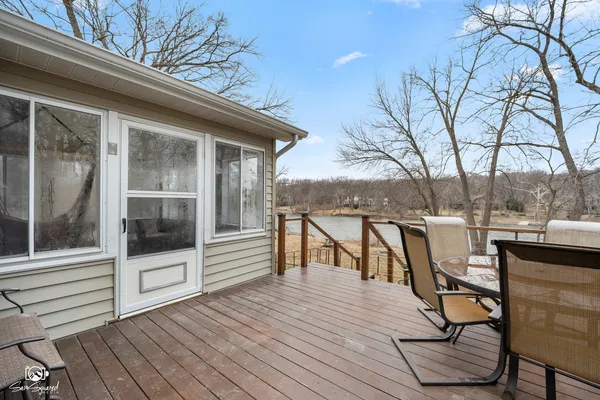 a view of a balcony with chairs and wooden floor