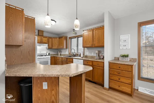 a kitchen with granite countertop a sink cabinets stainless steel appliances and a window