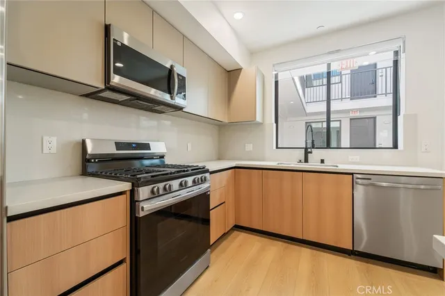 a kitchen with stainless steel appliances granite countertop a stove microwave and sink