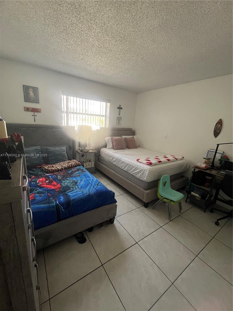 8145 Northwest 7th Street, Unit 211 Miami, FL 33126 - Photo 16 of 23 a bedroom with a bed and a window