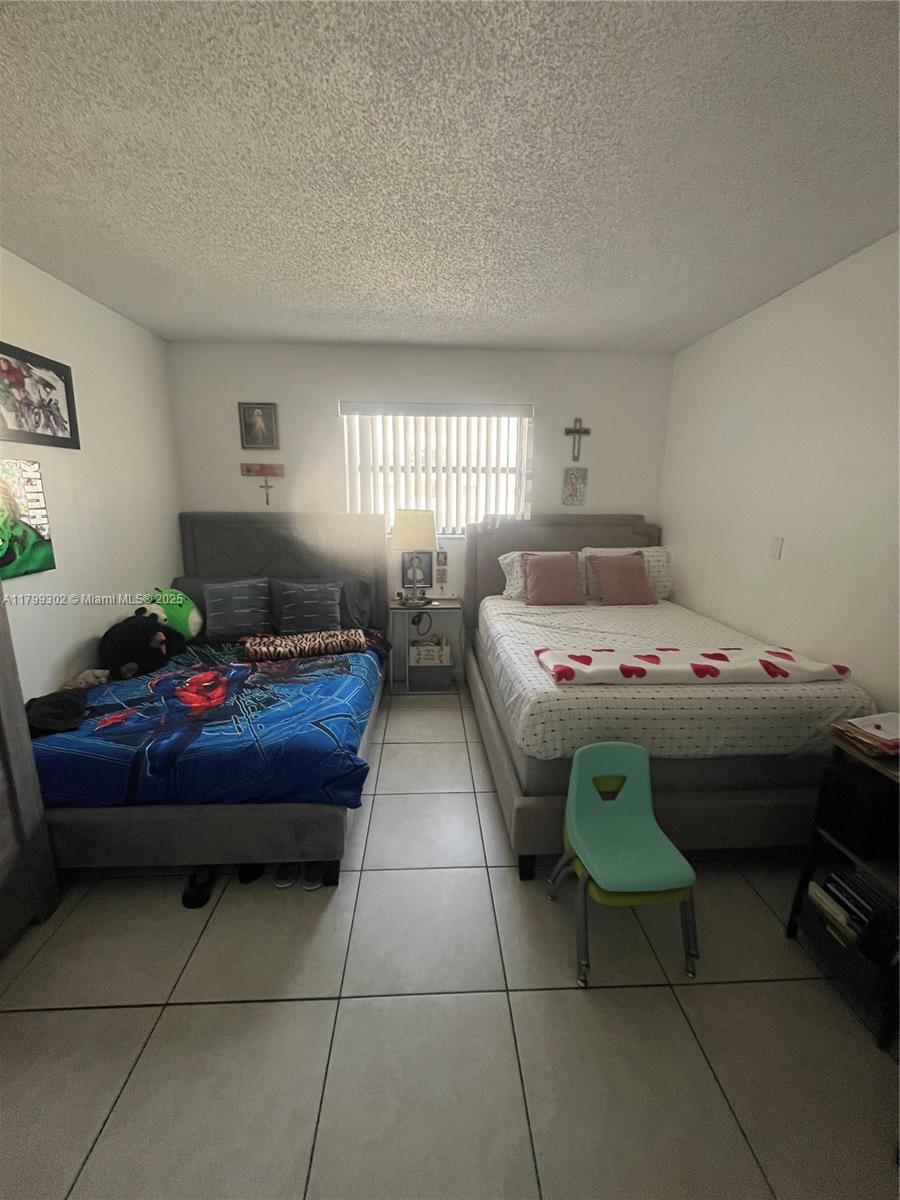 8145 Northwest 7th Street, Unit 211 Miami, FL 33126 - Photo 17 of 23 a bedroom with a bed and window