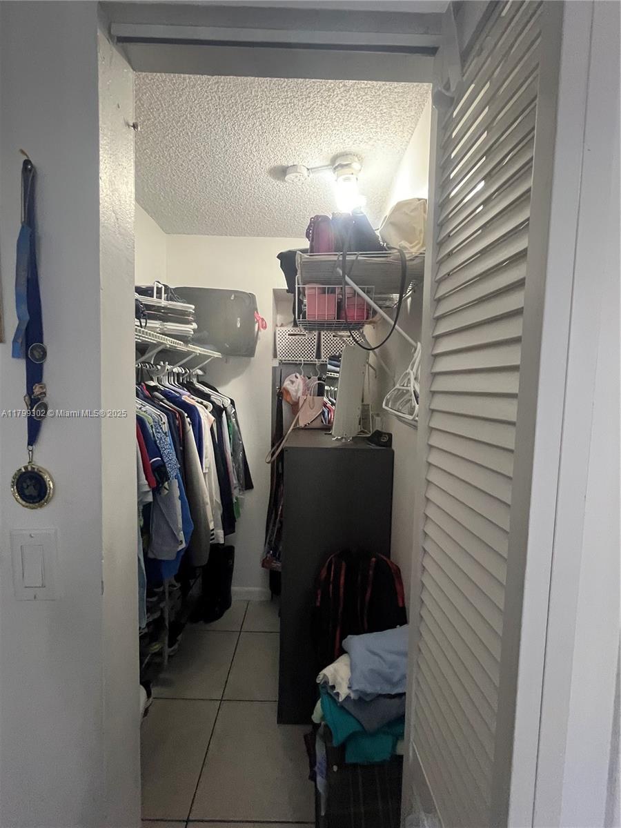8145 Northwest 7th Street, Unit 211 Miami, FL 33126 - Photo 19 of 23 a view of walk in closet with clothes and shoes