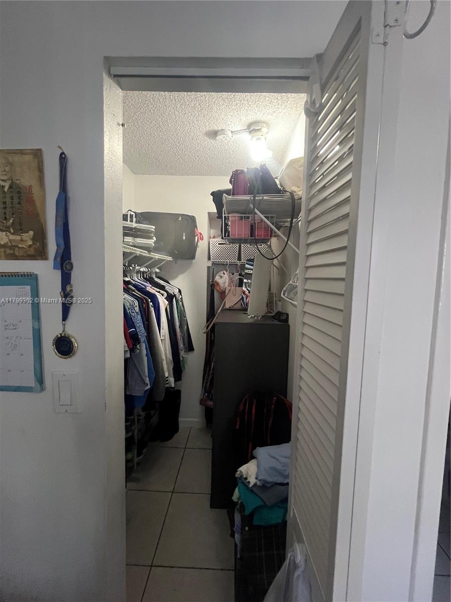 8145 Northwest 7th Street, Unit 211 Miami, FL 33126 - Photo 20 of 23 a view of walk in closet with clothes and shoes