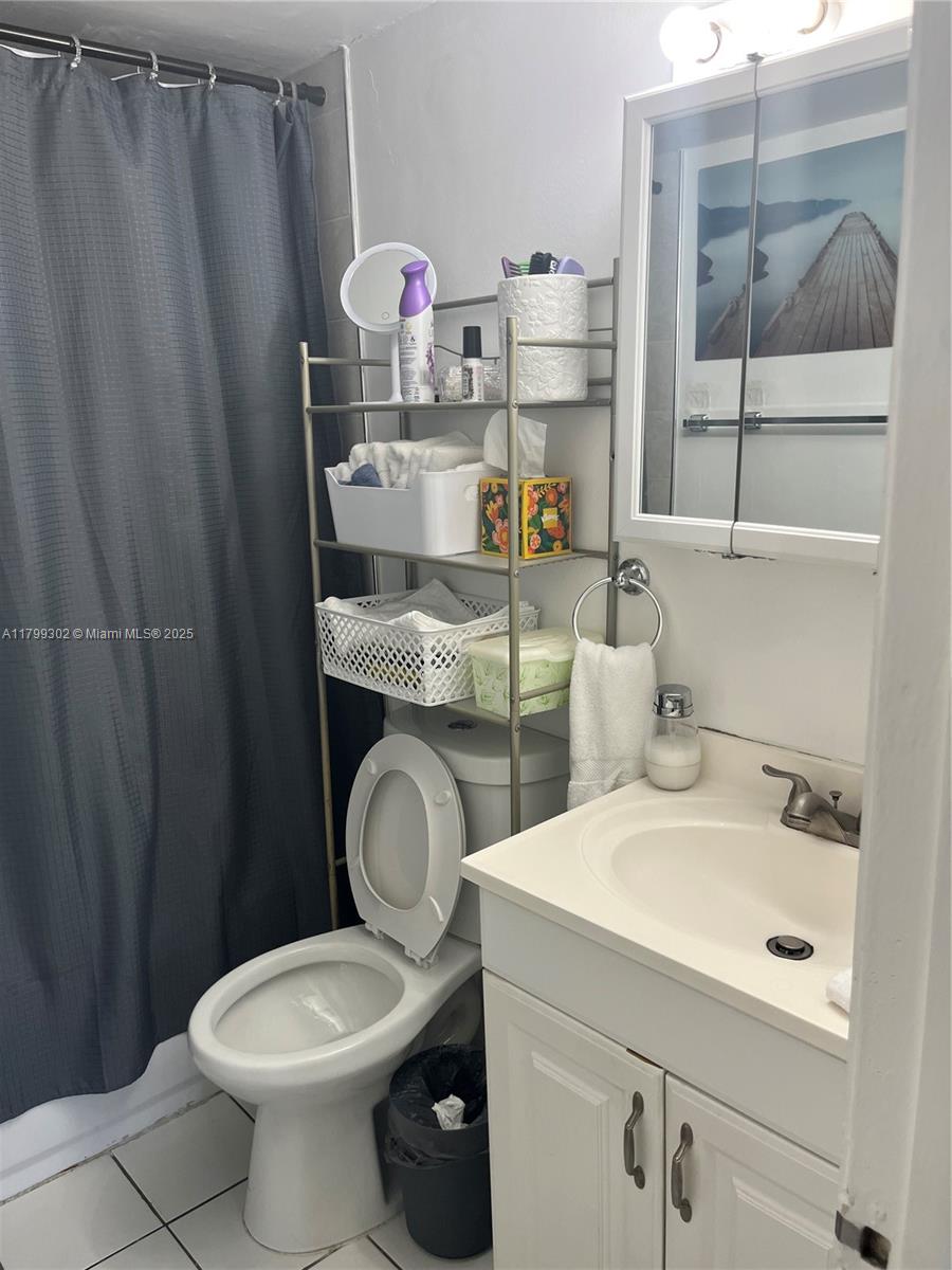 8145 Northwest 7th Street, Unit 211 Miami, FL 33126 - Photo 21 of 23 a bathroom with a sink a toilet and a mirror