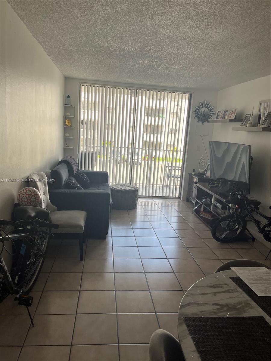 8145 Northwest 7th Street, Unit 211 Miami, FL 33126 - Photo 3 of 23 a living room with furniture and a floor to ceiling window