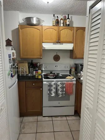 a kitchen with stainless steel appliances granite countertop a refrigerator and a stove