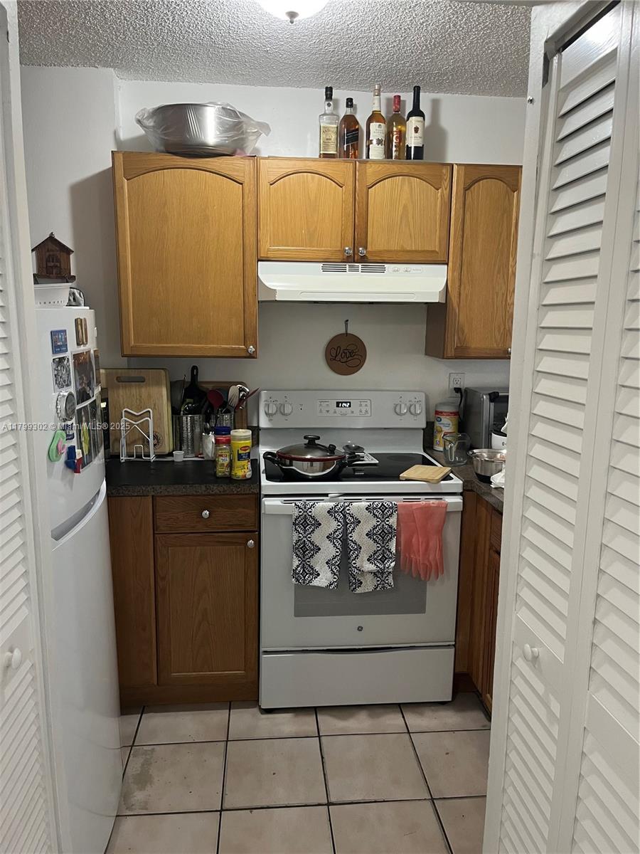 8145 Northwest 7th Street, Unit 211 Miami, FL 33126 - Photo 4 of 23 a kitchen with stainless steel appliances granite countertop a refrigerator and a stove