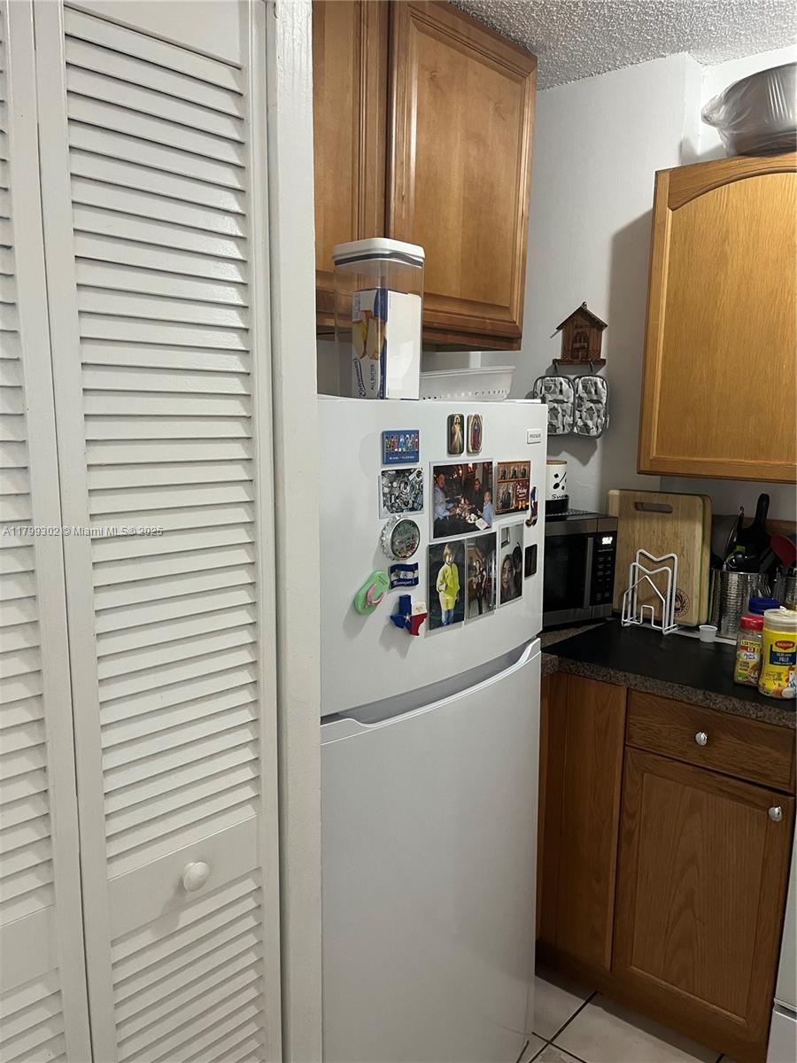 8145 Northwest 7th Street, Unit 211 Miami, FL 33126 - Photo 6 of 23 a kitchen with a refrigerator and a stove