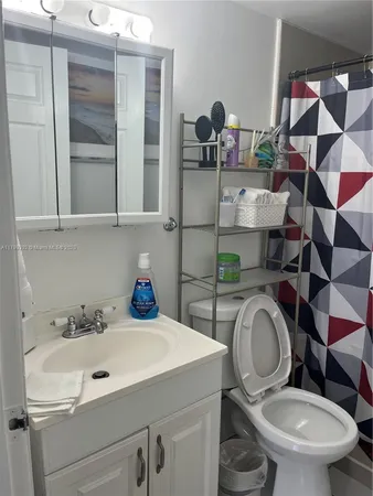 a bathroom with a sink mirror and toilet