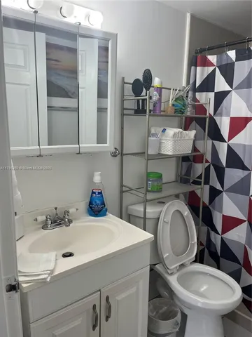 a bathroom with a sink mirror and toilet