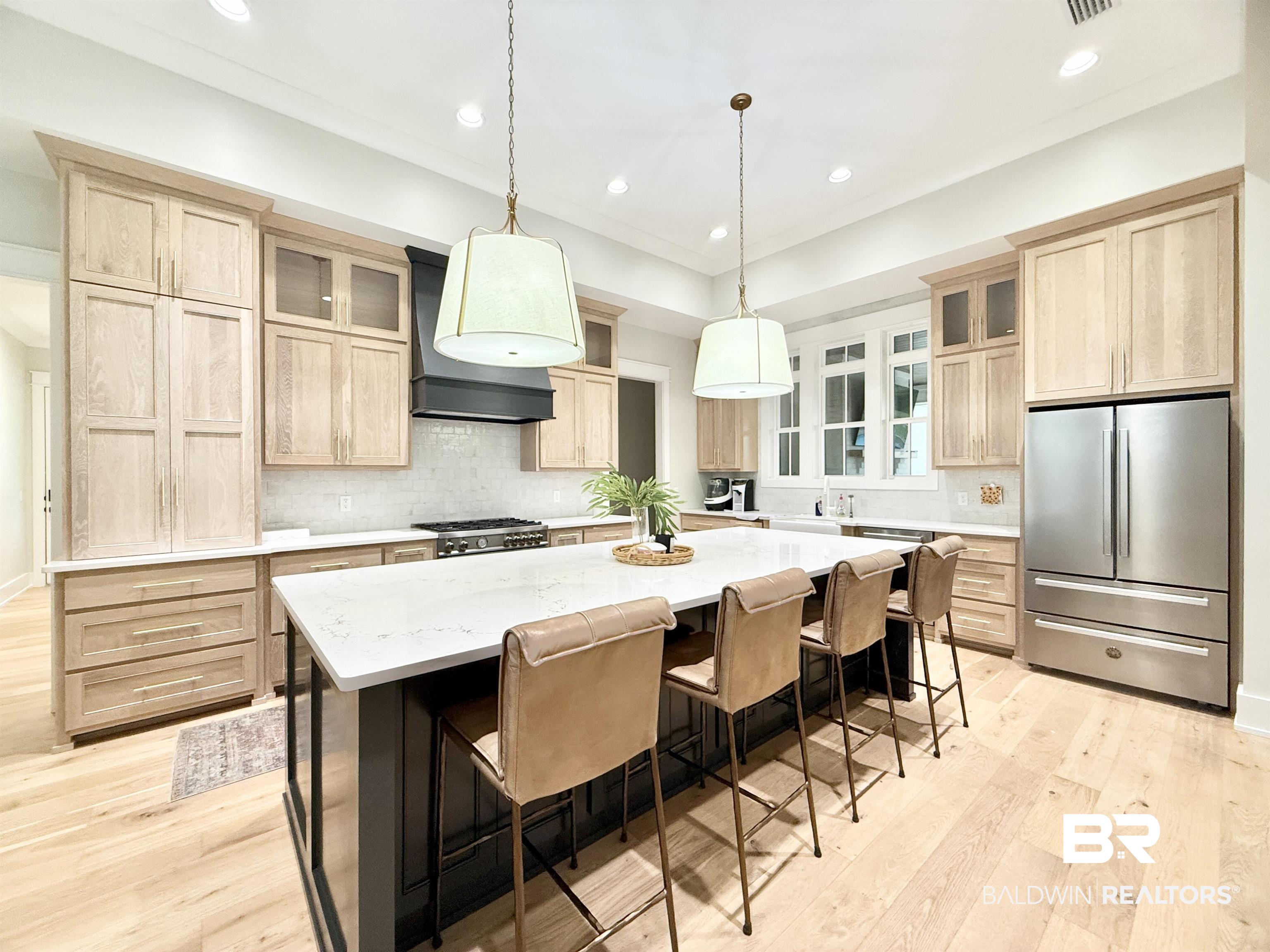 21767 Gallery Boulevard Fairhope, AL 36532 - Photo 12 of 74 Kitchen with light brown cabinets, stainless steel appliances, light wood-type flooring, recessed lighting, and a kitchen island