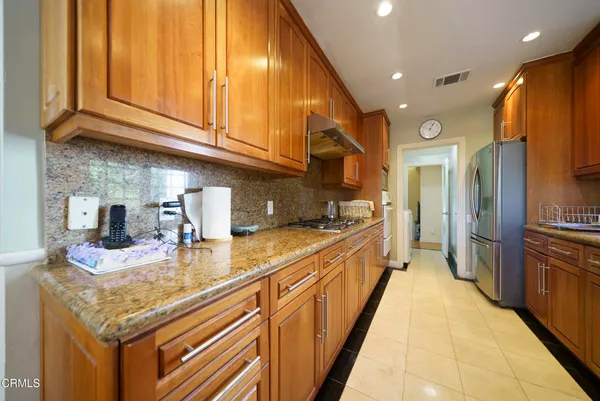 a kitchen with kitchen island granite countertop a sink and refrigerator