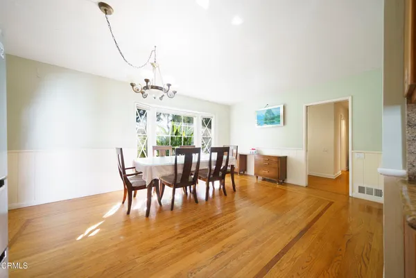 a dining room with furniture a chandelier and wooden floor