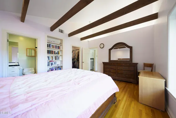 a spacious bedroom with a bed and wooden floor