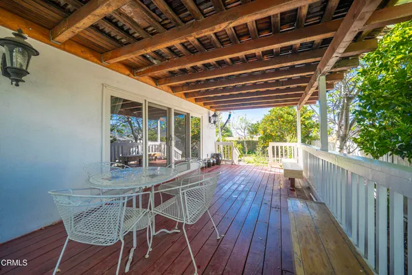 a patio with wooden floor a yard a table and chairs