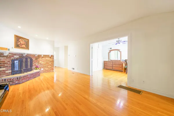 a view of a livingroom with wooden floor and a refrigerator