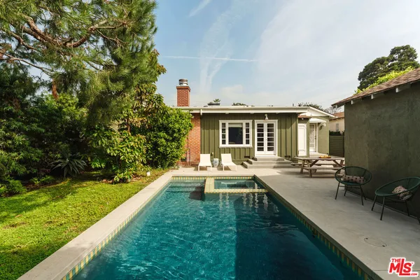a view of a house with backyard sitting area and garden