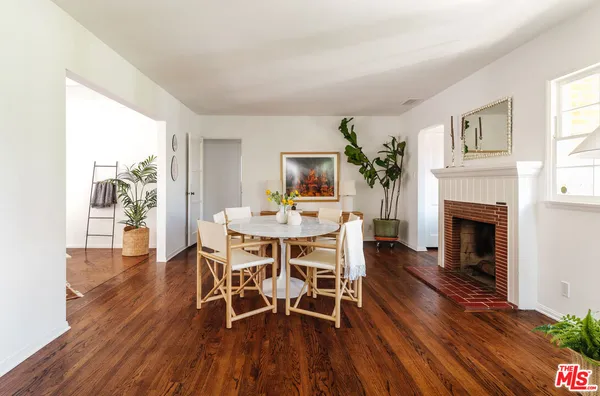 a dining room with furniture a fireplace and wooden floor