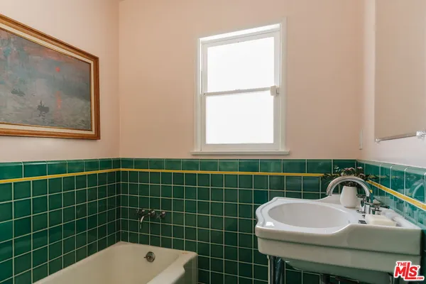 a bathroom with a sink a toilet a window and mirror