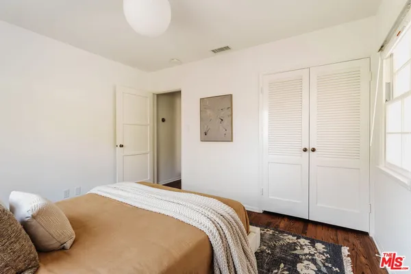 a bedroom with a bed and wooden floor