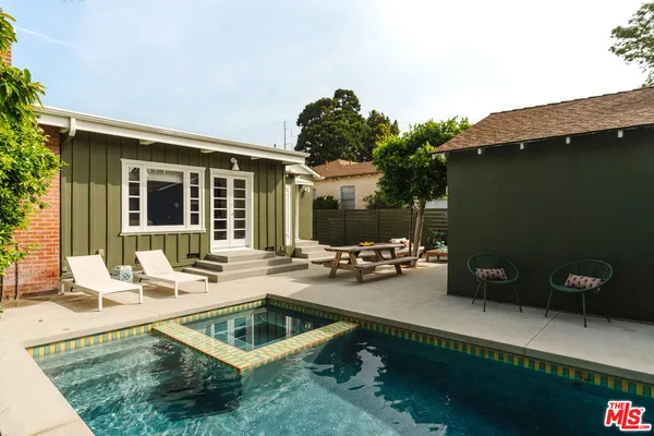 a view of a house and a swimming pool with a lounge chair