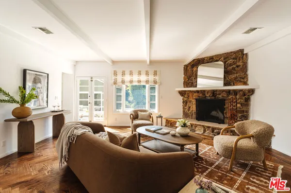 a living room with furniture a fireplace and a large window