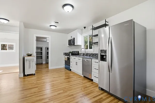 a kitchen with stainless steel appliances a refrigerator and a stove top oven