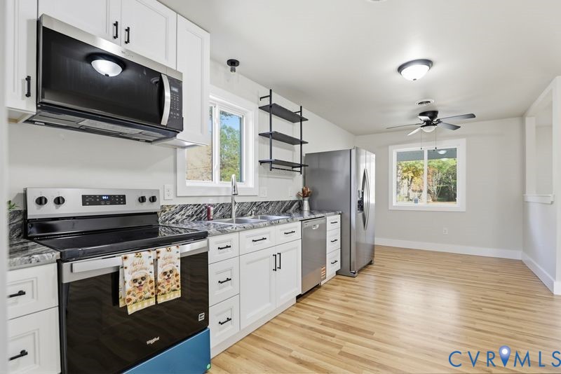 6010 Golden Wheel Road Providence Forge, VA 23140 - Photo 16 of 49 a kitchen with stainless steel appliances granite countertop a stove and a wooden floor
