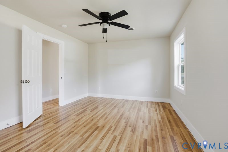 6010 Golden Wheel Road Providence Forge, VA 23140 - Photo 20 of 49 an empty room with wooden floor and a ceiling fan