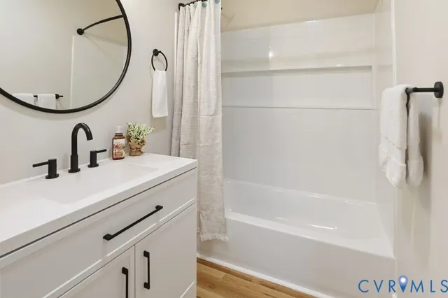 a bathroom with a sink and a mirror with bathtub