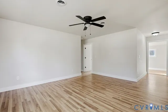 a view of an empty room with wooden floor