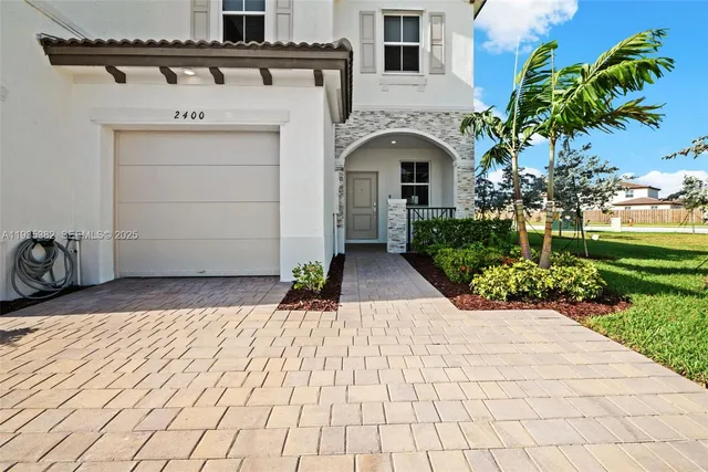 a front view of a house with a garden