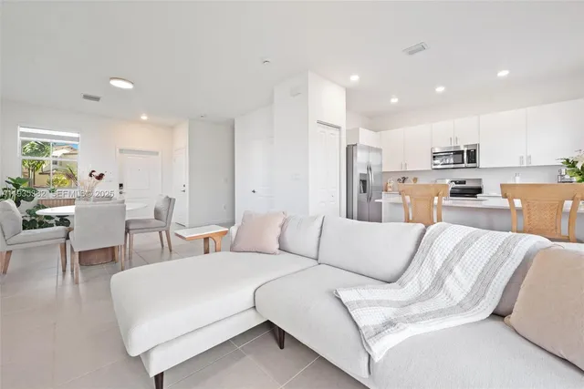 a living room with furniture and kitchen