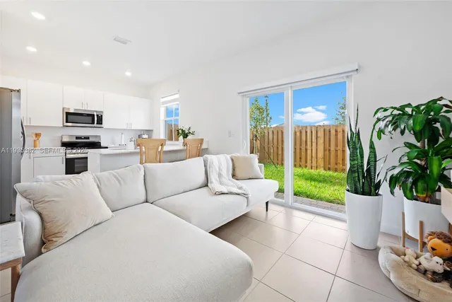 a living room with furniture a couch and a potted plant