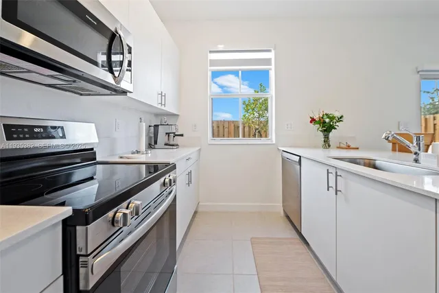 a kitchen with stainless steel appliances granite countertop a sink and a stove
