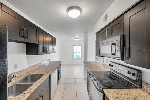 a kitchen with stainless steel appliances granite countertop a sink and a stove