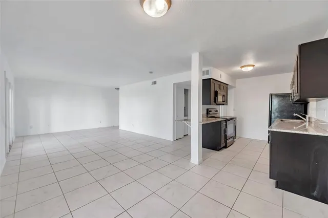 a view of an empty room with a fireplace and a window