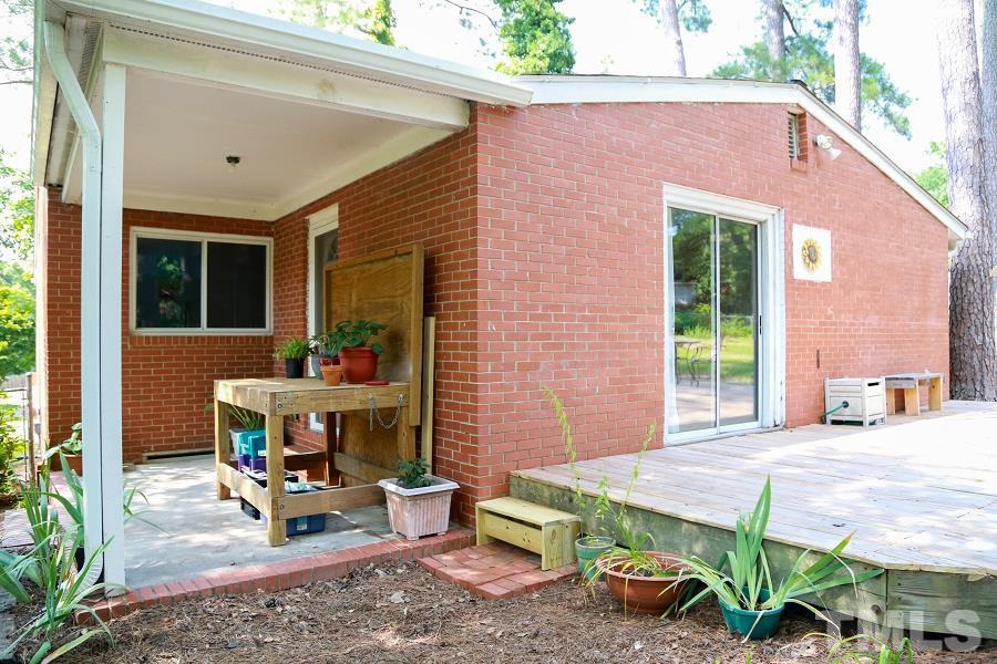 1501 Kelly Road Garner, NC 27529 - Photo 21 of 25 a view of a patio with table and chairs potted plants and floor to ceiling window