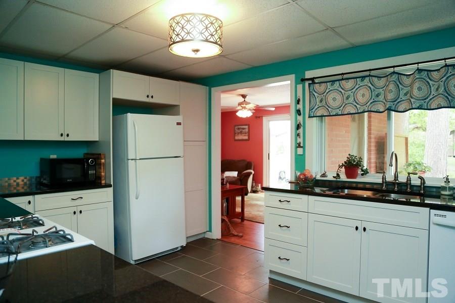 1501 Kelly Road Garner, NC 27529 - Photo 6 of 25 a kitchen with a refrigerator and a stove top oven