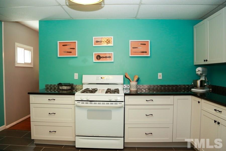 1501 Kelly Road Garner, NC 27529 - Photo 9 of 25 a kitchen with granite countertop white cabinets and white appliances