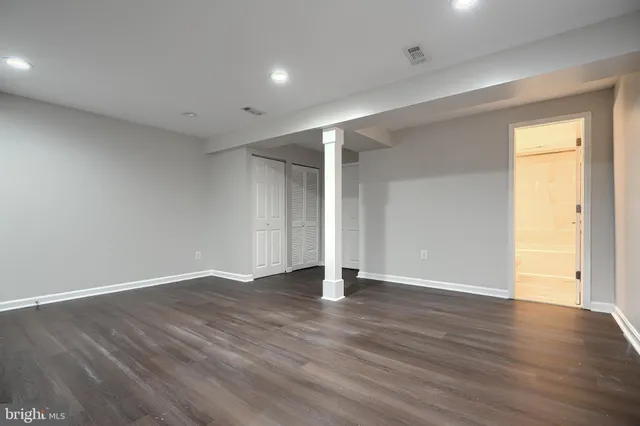 a view of an empty room with wooden floor
