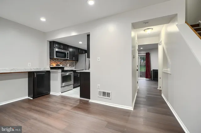 a view of a kitchen with a sink wooden floor and a living room