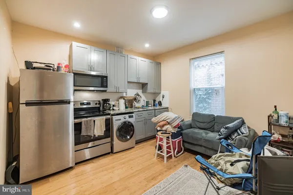 a kitchen with stainless steel appliances granite countertop a refrigerator stove microwave and sink
