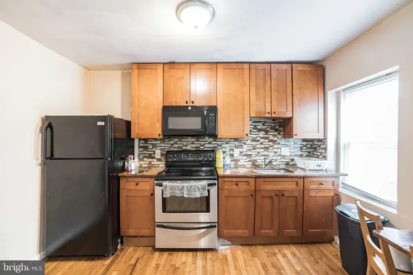 a kitchen with a refrigerator and a stove top oven