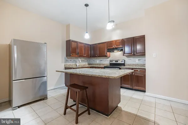 a kitchen with stainless steel appliances granite countertop a refrigerator a sink a stove a microwave and a refrigerator